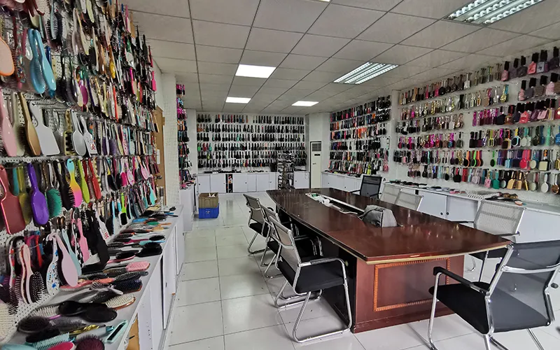 Multiple detangling brush models in various colours and handle designs displayed on a manufacturer showroom shelf