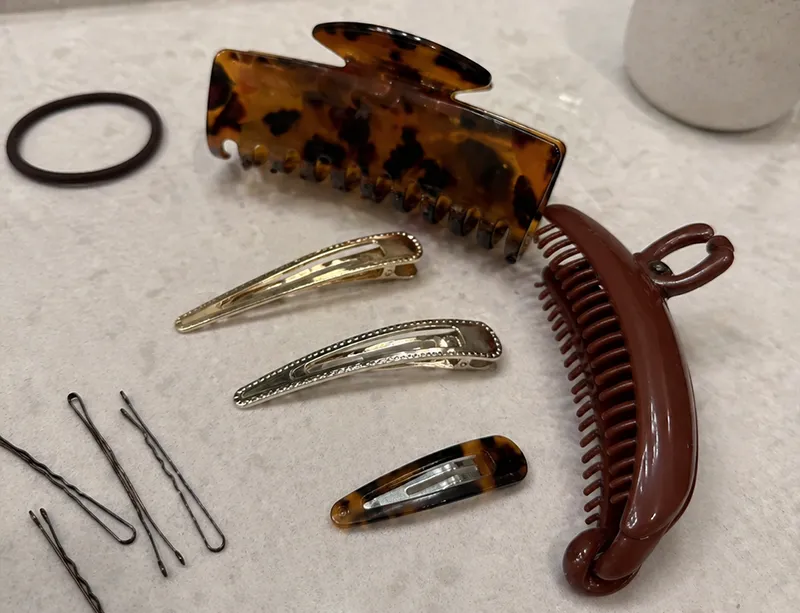 Several large hair clips including jaw clips, banana clips and barrettes arranged for thick hair comparison