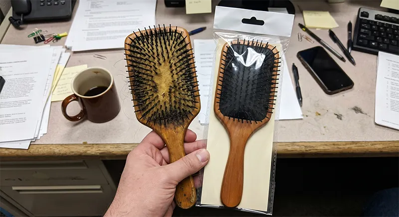Close-up of a worn hair brush with bent bristles and degraded cushion pad next to a new brush for comparison