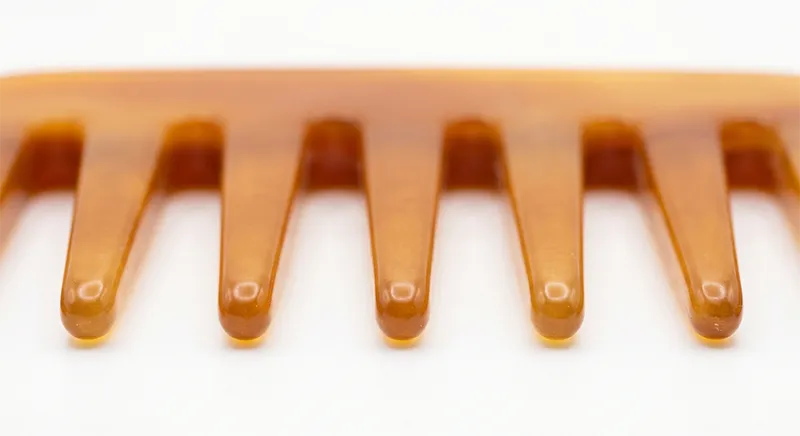 Wide-tooth comb showing rounded tooth tips and wide spacing between teeth for detangling fine hair