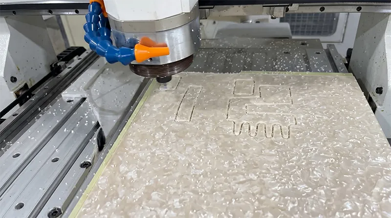 Acetate sheet being cut into claw clip blanks on a factory workstation during the production process