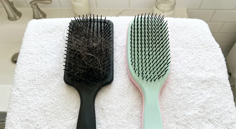 Side by side comparison of a stiff bristle brush with broken hair strands caught in it versus a clean flexible detangling brush