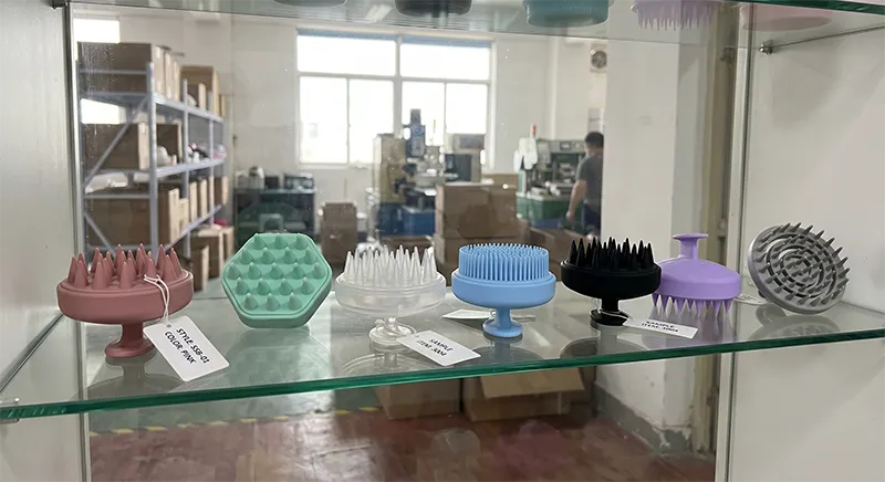 Multiple silicone scalp massage brushes and shampoo brushes in various colours displayed on a manufacturer showroom shelf
