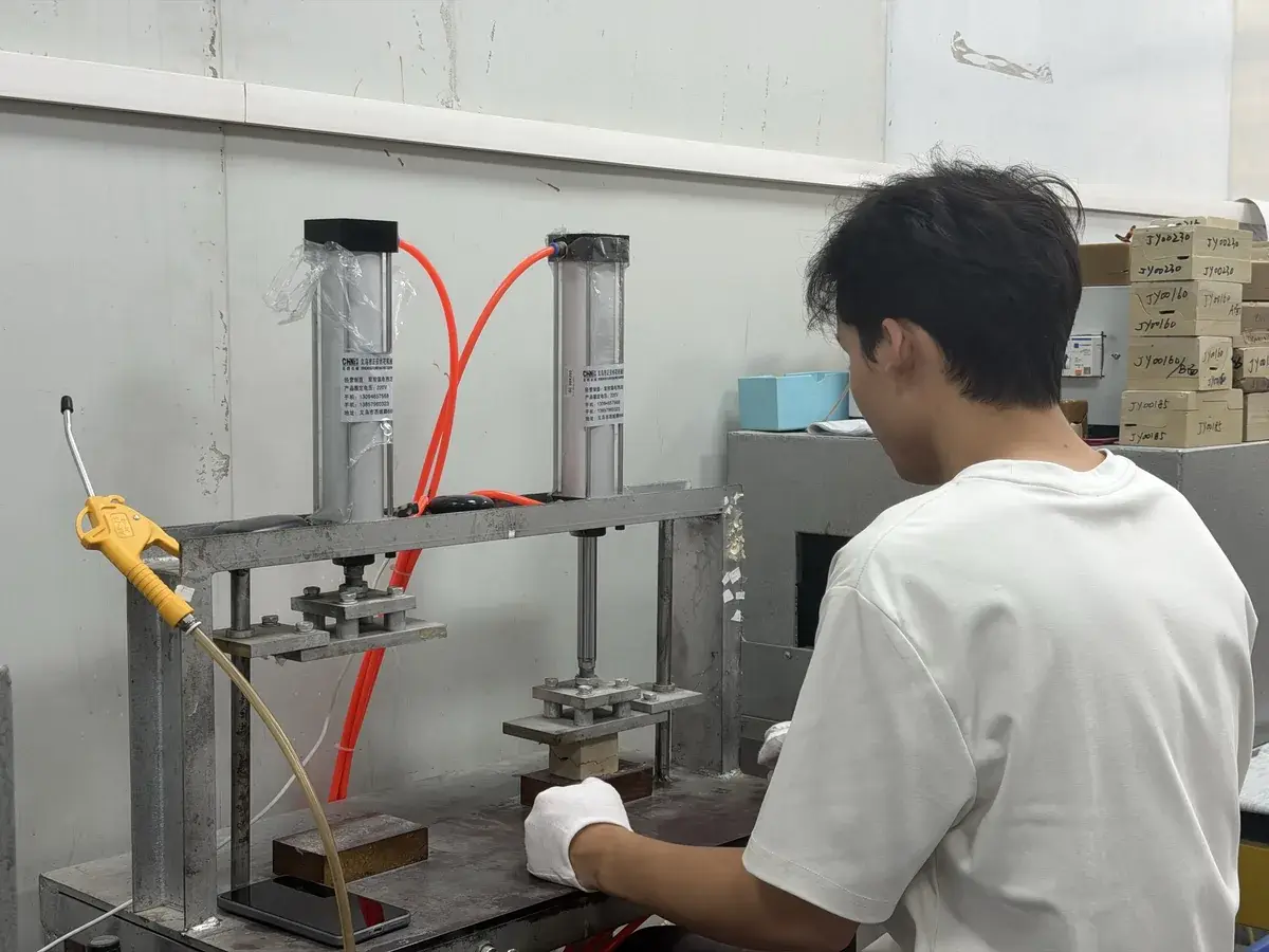 Worker pressing an acetate blank on a cutting press fitted with a cutting die