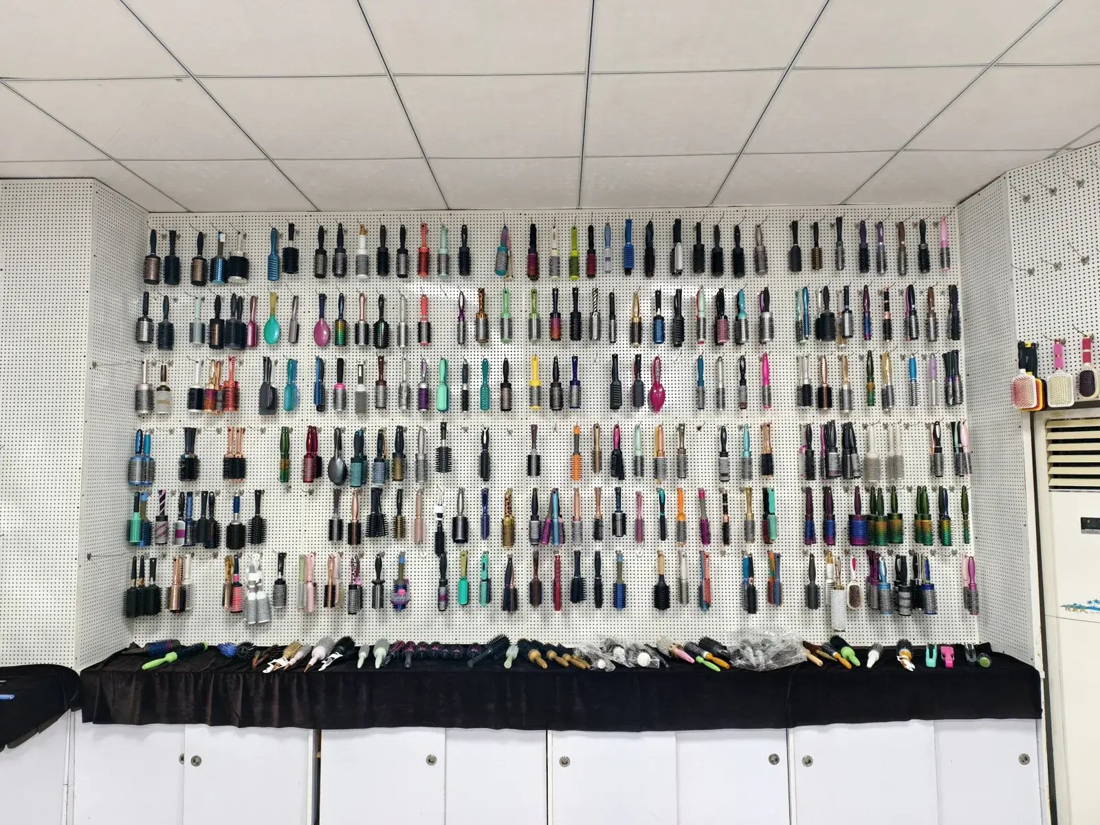 Sample wall showing hundreds of existing hair brush and comb styles that can be customised without a new mould