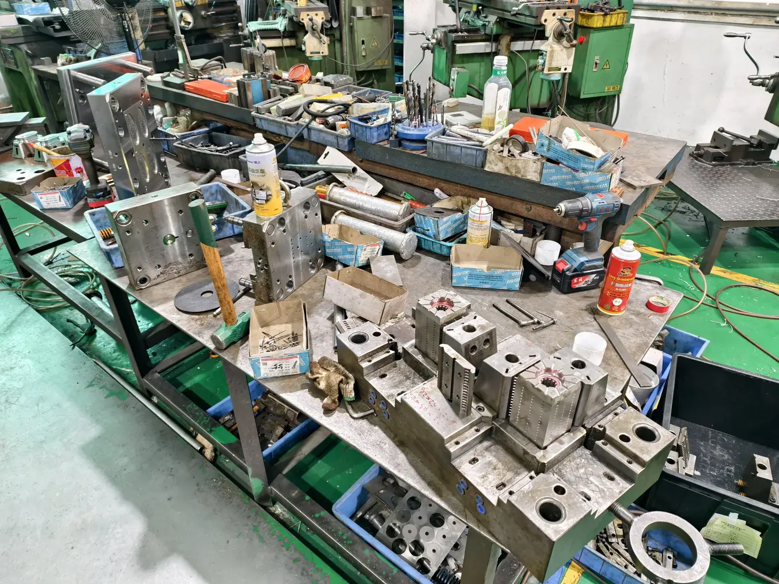 Steel injection mould components being machined and fitted on a workbench in the mould workshop
